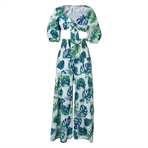 Détail de l'imprimé palmier tropical sur haut à col en V et pantalon large blanc