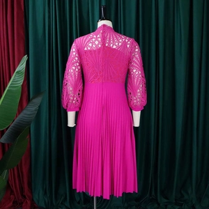 Macro detail of magenta floral lace bodice and pleated skirt texture on a midi dress