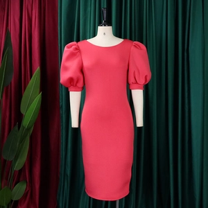 Detail of coral red puff sleeve bodycon dress with crew neck shown on a mannequin