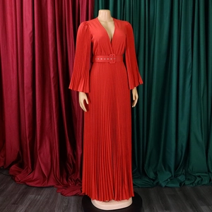 Détail d'une robe longue plissée rouge avec col en V, manches lanternes et ceinture