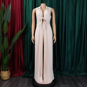 Detailed view of cream pleated jumpsuit featuring V-neckline and front bow tie detail