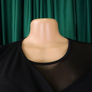 Detail of black long-sleeve top featuring a V-shaped mesh patchwork neckline on mannequin