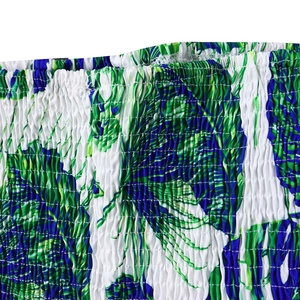 Détail du tissu smocké élastique avec imprimé feuilles tropicales et coutures extensibles
