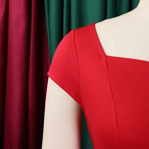 Détail de l'encolure carrée et des manches courtes de cette robe crayon rouge texturée