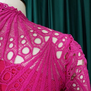 Detailed view of magenta lace hollow out dress with geometric patterns and high collar