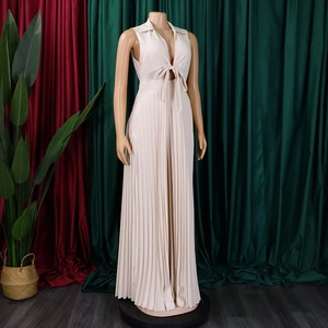 Close-up of beige deep V-neck pleated jumpsuit with elegant front tie-bow detail
