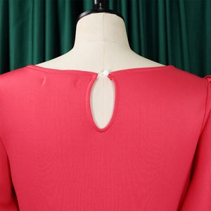 Detail of red dress featuring keyhole back closure with white button on round neck