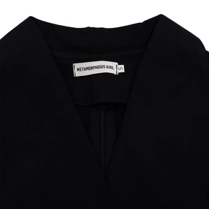 Détail de l'encolure en V et de l'étiquette de marque sur une robe africaine noire