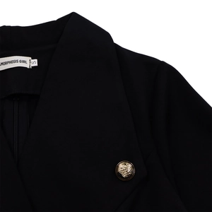 Détail du col à revers et bouton doré sur une robe noire à taille haute ajustée