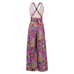 Detail of vibrant paisley print romper with backless cross straps and waist bow detail
