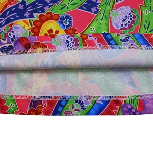Macro view showing high-quality overlock stitch and vibrant floral print on beach jumpsuit