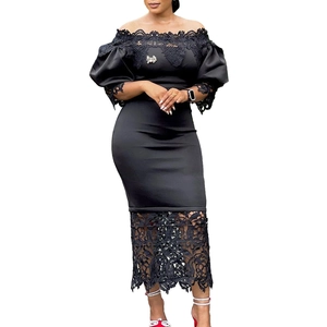 Close-up of black off-shoulder dress with lace detailing and elegant bow brooch