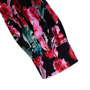 Detailed view of floral print cuffs with pleats on a black long sleeve vintage dress