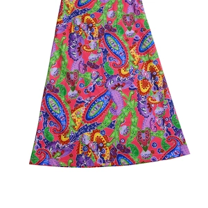 Detailed view of pink paisley pattern and vibrant floral prints on a flowing skirt hem