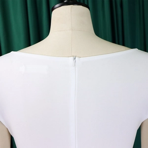 Gros plan du décolleté de la robe blanche avec une fermeture éclair invisible discrète