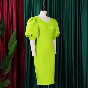 Detail of neon green puff sleeves and round neckline on a slim fit midi dress