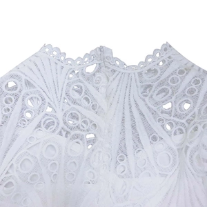 Detail of white lace dress showing intricate hollow-out texture and invisible back zipper