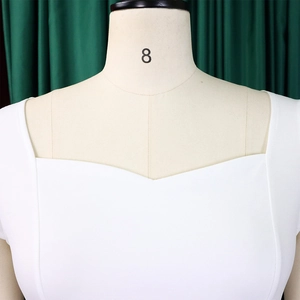 Détail de l'élégante encolure carrée en forme de cœur sur cette robe crayon blanche