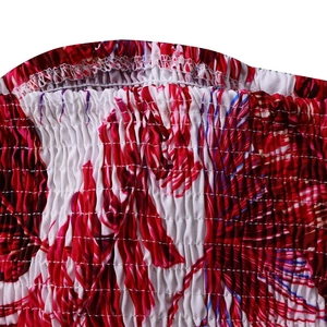 Détail du tissu smocké à la taille avec motif floral tropical rouge et blanc