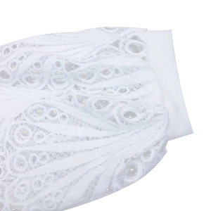 Macro shot of white lace dress detailing floral embroidery and pleated hollow texture