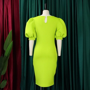 Detail view of neon green puff sleeve dress featuring back teardrop cutout on a mannequin