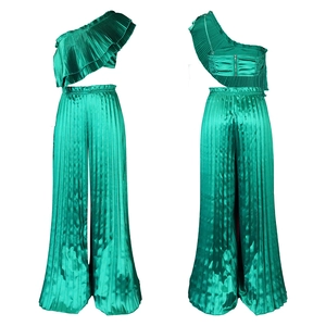 Detail of emerald green pleated two-piece set featuring one-shoulder ruffle top and wide-leg pants