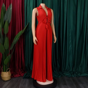 Detail of red pleated jumpsuit featuring deep V-neckline and stylish bow tie detail