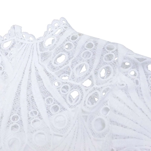 Detailed view of white lace hollow embroidery with intricate floral and geometric patterns