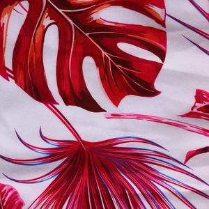 Vue détaillée du motif de feuilles tropicales de monstera sur un tissu blanc texturé