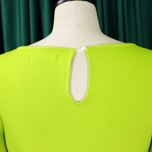 Detail view of fluorescent green dress back neckline with keyhole and white button closure