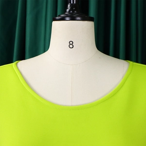 Close-up of double-needle neckline stitching on neon green puff sleeve dress