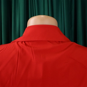 Detail view of the back of a red V-neck jumpsuit showing sharp collar and smooth fabric texture