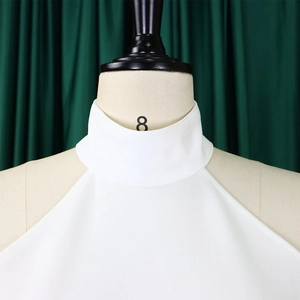 Detail of white sleeveless high neck top with woven texture and premium tailoring on a mannequin