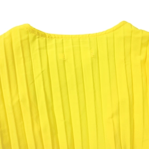 Détail de robe jaune avec de fins plis verticaux et encolure ronde sur tissu léger