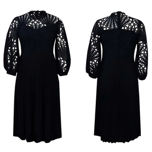 Detail of black midi dress showing intricate lace hollow-out sleeves and pleated A-line skirt