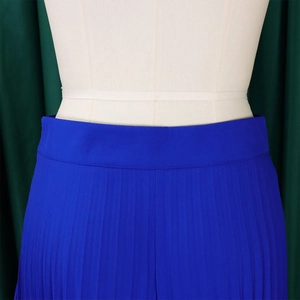 Macro shot of high waist pleated details on royal blue wide-leg trousers for women