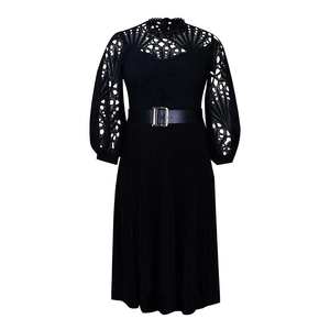 Detailed view of women's black lace dress featuring hollow-out patterns and pleated skirt