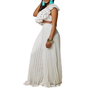 Detail of white two-piece set featuring pleated wide-leg trousers and ruffled off-shoulder top