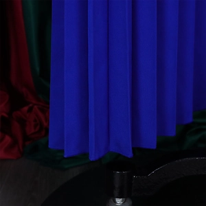 Detail of royal blue pleated wide-leg trousers showing fabric texture and hem finish