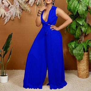 Royal blue pleated wide-leg jumpsuit with V-neck and waist tie on a vacation background