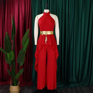 Detail of red pleated wide-leg pants set with elegant gold waist belt and fringe tassels