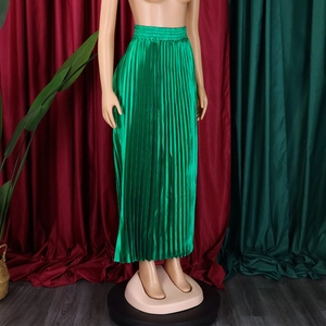 Detail of emerald green pleated maxi skirt showing elastic high waist and satin texture