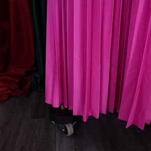Dettaglio dell'abito a pieghe rosa fucsia con pieghe verticali fitte e trama del tessuto
