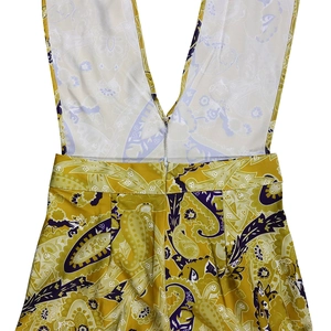 Detail view of back deep V-neck cut and invisible zipper on yellow paisley print jumpsuit