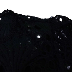 Macro shot of intricate black lace embroidery and hollow-out floral details on the dress