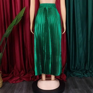 Detail view of high-waisted pleated green satin skirt with silky metallic luster