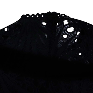Detail of black floral lace fabric with intricate hollow-out texture and scalloped edges