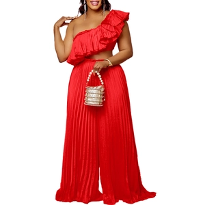 Detail of red off-shoulder ruffle top and pleated wide leg trousers two-piece set