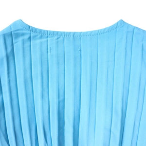 Détail de l'encolure d'une robe plissée bleu clair avec de fines bandes verticales et coutures