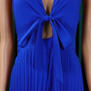 Detail of royal blue V-neck jumpsuit with bow tie and elegant pleated fabric texture